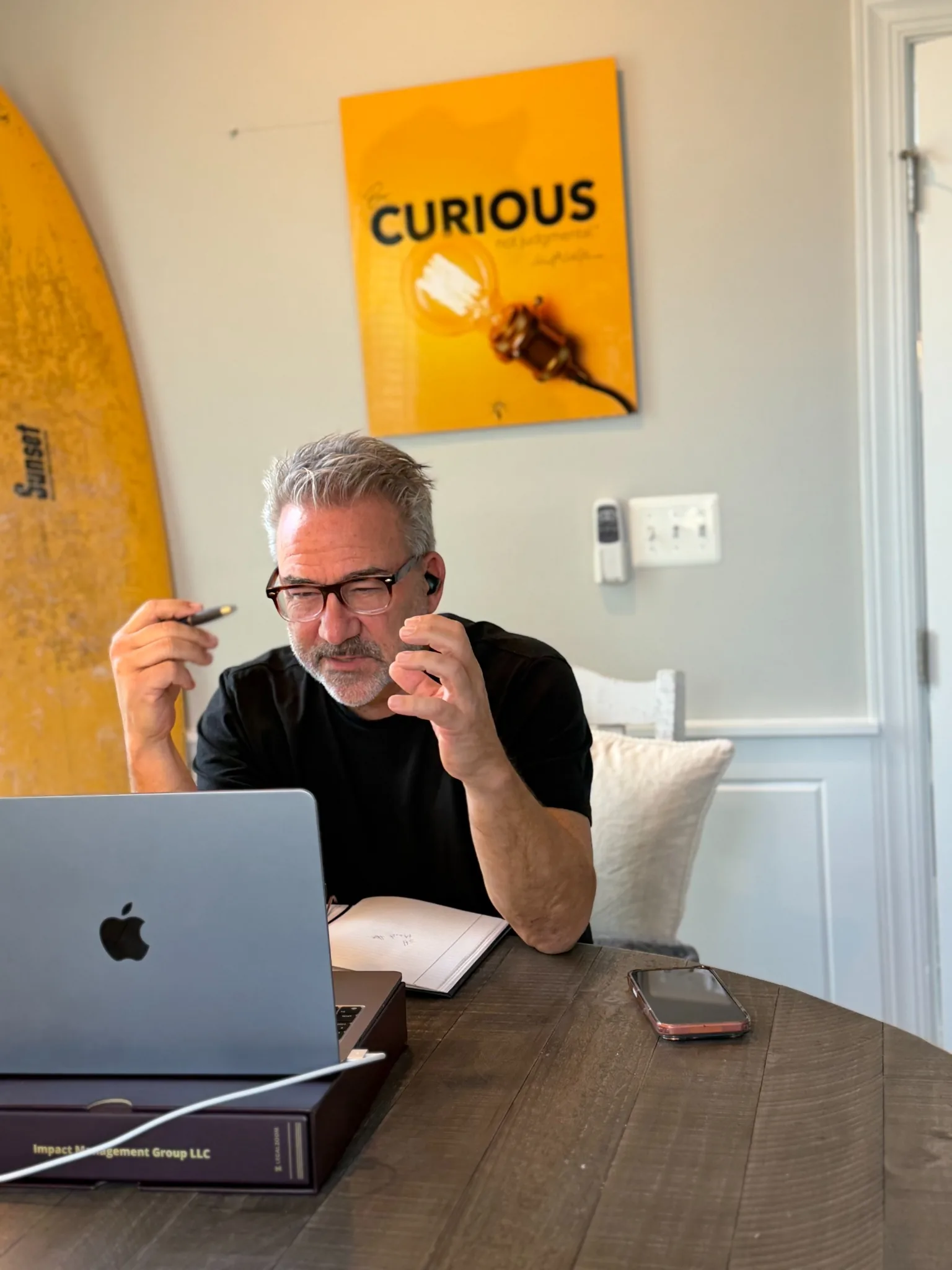 Mark P. Fisher animated in a conversation with a notebook and Curious sign behind him